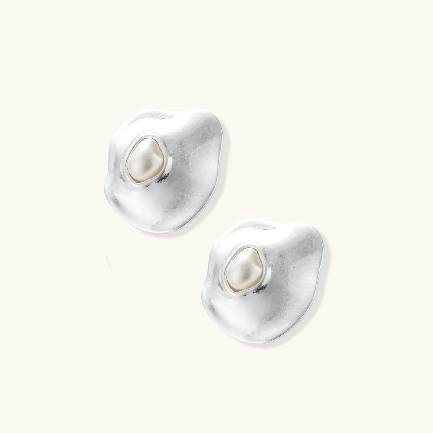 Organic silver stud earrings with white resin pearl centers in fluid stone-like shapes on light background.