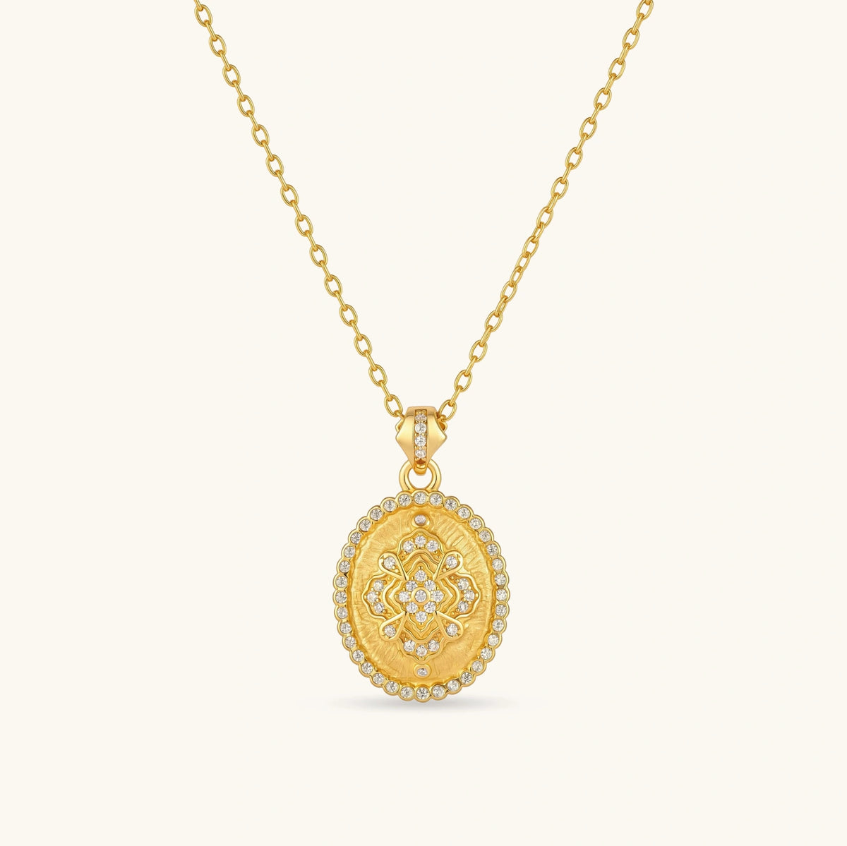 Oval gold coin pendant with pave CZ mandala motif and beaded border on an 18K gold-plated cable chain.