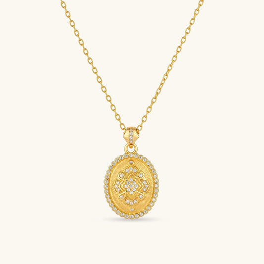 Oval gold coin pendant with pave CZ mandala motif and beaded border on an 18K gold-plated cable chain.